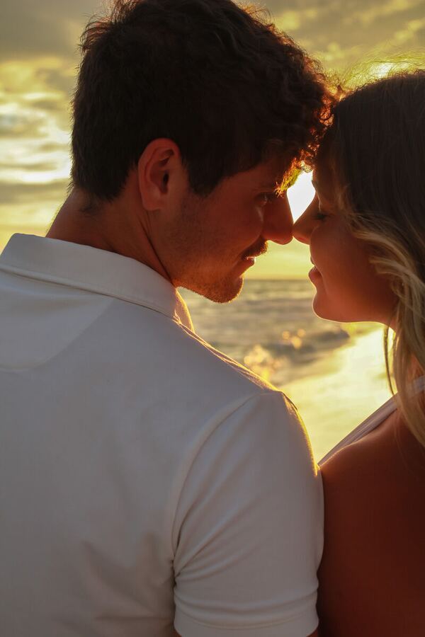 Couple nose to nose on the beach at sunset