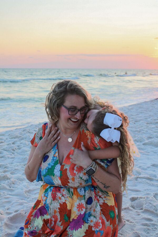 Mom laughing with her daughter on the beach